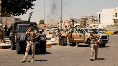Libyan army forces and vehicles are stationed in a street in the country’s capital of Tripoli in July. The ICC has submitted new applications for arrest warrants stemming from his investigations of alleged war crimes and crimes against humanity in the country. AP