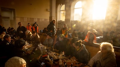 People wait as their electronic devices charge at the main railway station in Kherson, a city in which power is in short supply. Getty