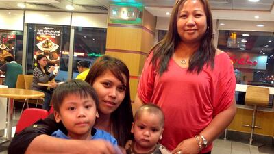 Kingly Cruzado, 4, his brother Princely, 1, their mum Queeny Cruzado and her sister Nerisa Loyola. Jessica Hill for The National