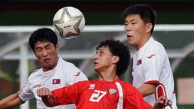 Ri Chol Myong, left, and Kim Yong Jun of North Korea compete for the ball with the UAE's Omar Abdulrahman during the quarter-final match.