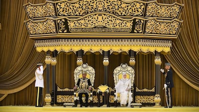 Malaysia's King Sultan Abdullah and Queen Tunku sit on the throne at the National Palace in Kuala Lumpur. Malaysia Information Ministry via AP