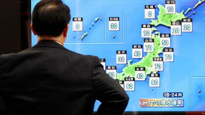 A man watches a public TV of weather forecast in Tokyo. AP