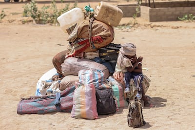 Sudanese children sit by their family's belongings at the border between Chad and Sudan before going to the Tine transit camp in Chad's Wadi Fara province. AP