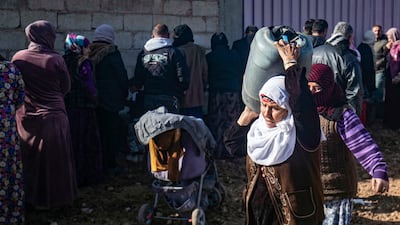 A woman walks home with a container filled with paraffin in Qamishli, Syria, amid a shortage of cooking gas. AFP