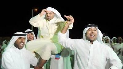 Kuwaiti parliamentary candidate Rakan Youssef Al Nesif (centre) celebrates his victory with supporters at his campaign headquarters in Kuwait City.
