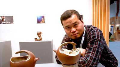 The artist Qian Zhangfa with his ceramic teapot “Be Together” displayed at the China Art Exhibition at the Abu Dhabi National Exhibition Centre. Ravindranath K / The National