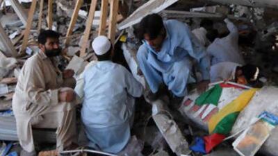 Pakistani area residents inspect a destroyed building a day after a suicide attack in Peshawar on September 7, 2008.