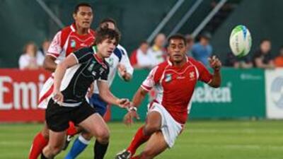 The Arabian Gulf's Jonny MacDonald, left, and Tonga's Peasipa Moimoi chase the ball during yesterday's game at The Sevens.
