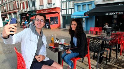 Mathys Marquez takes a selfie as he has breakfast with his cousin Juna Marquez at a cafe in Bayonne, southwestern France. AP Photo