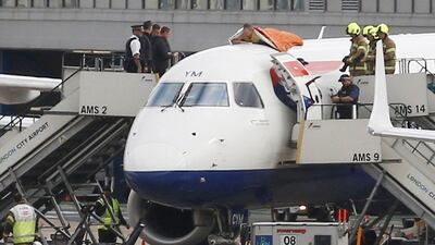 An Extinction Rebellion activist sits on top of a plane at London City Airport. PA
