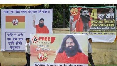 Supporters of Swami Ramdev carry his portrait before raising it in the Ramlila grounds where he was scheduled to start his anti-corruption fast in New Delhi yesterday.