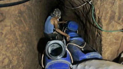 A Palestinian man receives goods from Egypt through a tunnel dug 15 meters underneath the border in Rafah refugee camp.