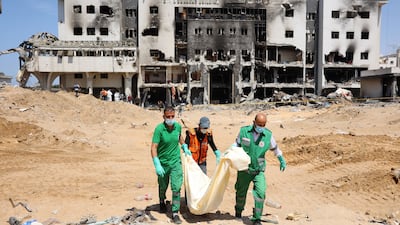 Palestinian personnel recover human remains on the grounds of Al Shifa Hospital in Gaza city in April 2024, after two-week siege by Israeli forces. AFP