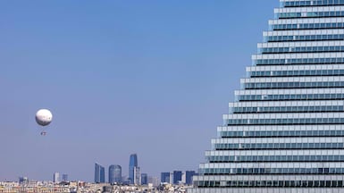 The Ballon Generali de Paris, a floating laboratory which measures pollution, hovers beyond Triangle Tower on the south-western edge of the French capital with La Defense business district in the background. AFP