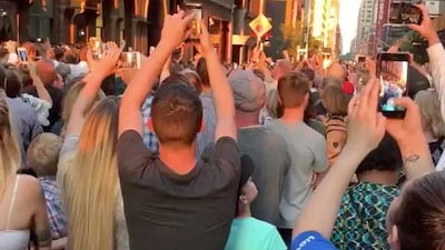 People evacuated from a Carnegie Hall concert during a blackout due to widespread power outages in Manhattan listen to the choir singing on the street. Reuters