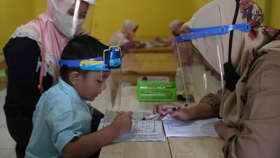 Teachers and students wear protective gear as a precaution against the coronavirus outbreak during a class at a Quran educational facility at on the outskirts of Jakarta, Indonesia. AP Photo