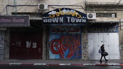 A woman walks past closed shops in Jerusalem as a general strike was called following US President Donald Trump's decision to recognise Jerusalem as the capital of Israel, on December 7, 2017 in east Jerusalem. / AFP PHOTO / Ahmad GHARABLI