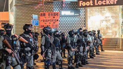 HONG KONG, CHINA - DECEMBER 24: Riot police secure an area as they hold up a warning flag during a standoff with protesters on December 24, 2019 in Hong Kong, China. Anti-government protesters rallying on Christmas Eve in Hong Kong continue their demands for an independent inquiry into police brutality, the retraction of the word "riot" to describe the rallies, and genuine universal suffrage. (Photo by Anthony Kwan/Getty Images)
