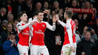 Arsenal's Mesut Ozil, centre, celebrates scoring their second goal with Hector Bellerin and Aaron Ramsey. Stefan Wermuth / Reuters