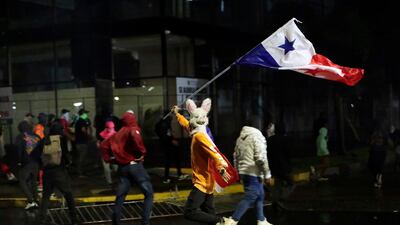 A protester runs amid clashes with police during a march against copper mining in Panama City. EPA