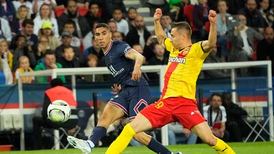 PSG full-back Achraf Hakimi, left, swings in a cross as Lens' Ignatius Ganago attempts a block. AP