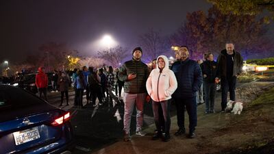 Onlookers gather at the scene where the single-engine Mooney M20J was tangled in live power cables more than 33 metres up. AP