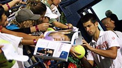 Serbia's Novak Djokovic signs autographs for fans following his victory over Ivan Ljubicic.