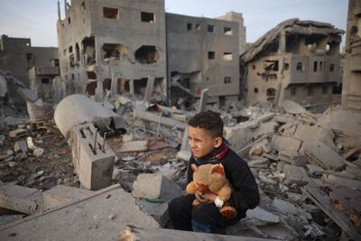 A Palestinian boy sits on the rubble of a building, destroyed in an Israeli strike on Nuseirat refugee camp in Gaza. AFP