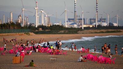 Beachgoers watch the sunset in the city of Dongfang on the western side of Hainan. John Ruwitch / Reuters