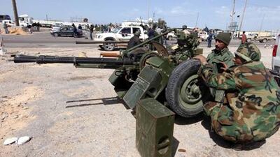 Libyans belonging to the anti-government forces keep watch next to their heavy weaponry in Brega, eastern Libya.