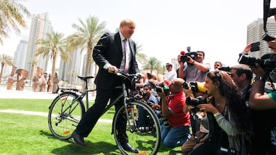 Boris Johnson, mayor of London, rides a bicycle and pretends to crash into media assembled outside Pavilion Downtown in Dubai. PSarah Dea/The National