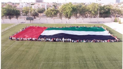 Pupils at The American Community School, Abu Dhabi, holding the first giant UAE flag before Trident Support raised it on the world record 123-metre flagpole on the Corniche Breakwater in 2001.
