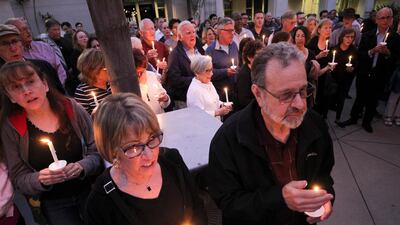 People from the community join members of the Rancho Bernardo Community Presbyterian Church in a candlelight vigil for the Chabad of Poway synagogue shooting victims in the Rancho Bernardo neighborhood of San Diego, California, Saturday, April 27, 2019. The San Diego Union-Tribune via AP