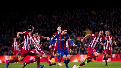 Lionel Messi runs with the ball between, from left to right: Filipe Luis, Nicolas Gaitan and Diego Godin. Alex Caparros / Getty Images