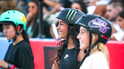 Women skateboarders watch the action