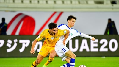 Australia forward Mathew Leckie, left, vies for the ball with Uzbekistan midfielder Ikram Alibaev. AFP
