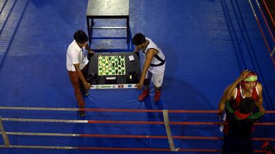 Attendants remove the chessboard from the boxing ring on Monday between rounds at the National Chess Boxing Championship in Kolkata, India. Dibyangshu Sarkar / AFP