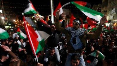 Palestinians celebrate as they watch a screen showing the UN General Assembly votes on a resolution to upgrade the status of the Palestinian Authority to a non-member observer state. AP Photo / Majdi Mohammed