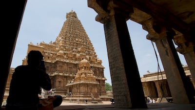 A visitor takes a picture of the temple, an architectural marvel