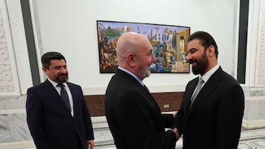 Iraq's President Nizar Amede, centre, with new prime minister-designate Ali Al Zaidi. Iraqi Presidency / AFP