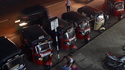 Sri Lankan three-wheeled taxi drivers wait for passengers along a road in Colombo on August 22, 2018. (Photo by LAKRUWAN WANNIARACHCHI / AFP)