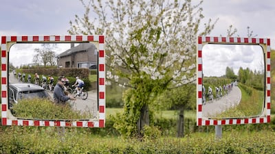 Riders are reflected in roadside mirros as they cycle during the 2026 Amstel Gold Race in Maastricht, Netherlands. AFP
