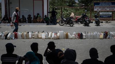 Makeshift jerry cans are lined up in order as people queue for fuel in Palu. Getty Images
