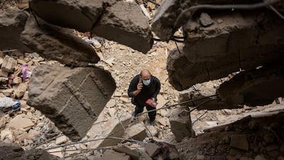 A resident looks for belongings among the rubble of an apartment building, destroyed during Israeli strikes in Beirut. Reuters