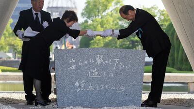 Hiroshima Mayor Kazumi Matsui, right, places a list of atomic bomb victims in the cenotaph during the Peace Memorial Ceremony at Peace Memorial Park in Hiroshima. EPA