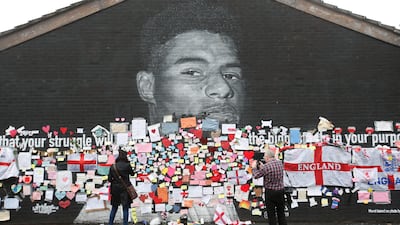 People place messages of support over offensive graffiti on a mural of England player Marcus Rashford in Withington, Manchester. Reuters