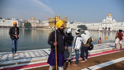 A Sikh guard patrols the area as devotees arrive to worship at the Golden Temple in Amritsar, India. A man was beaten to death on Saturday after being accused of trying to commit a sacrilegious act inside the historic temple. AP