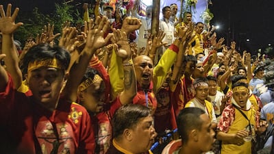 Filipino Catholic devotees raise their hands as they take part in the annual procession of the Black Nazarene. Getty