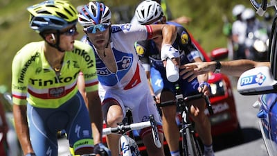 French rider Thibaut Pinot (C) of the FDJ team takes a water bottle from the team car as Polish rider Rafal Majka (L) of the Tinkoff team and German rider Tony Martin (R) of the Etixx-Quick Step team climb the Col du Tourmalet during Stage 8 of the 103rd Tour de France cycling race over 184km between Pau and Bagneres-de-Luchon, France, 09 July 2016. Yoan Valat / EPA