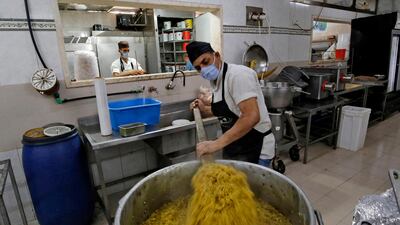 Palestinian cooks prepare food at a restaurant's kitchen to be delivered to a centre where people returning from Israel and Egypt are quarantined as a precaution against the COVID-19 coronavirus pandemic, in Gaza City. AFP